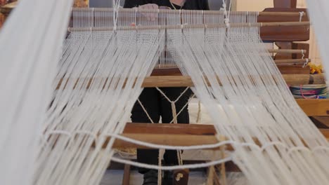 The-moving-parts-of-a-traditional-loom-as-a-woman-weaves-fabric