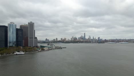 Aerial-view-of-the-Whitehall-Terminal-with-Brooklyn-background,-in-cloudy-NYC---pan,-drone-shot