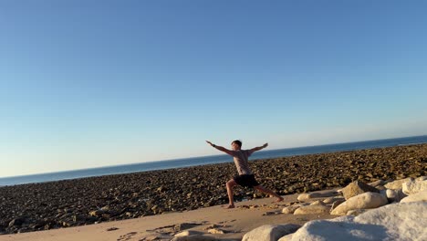 Joven-Haciendo-Movimientos-De-Yoga-Frente-Al-Océano-Atlántico-En-Una-Playa-Vacía