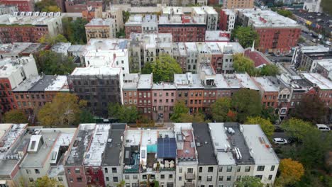 Aerial-view-over-streets-of-Harlem,-cloudy,-fall-day-in-New-York,-USA---tilt,-drone-shot