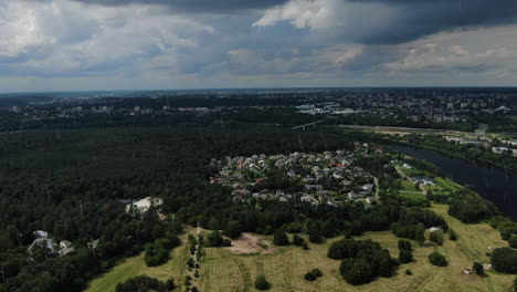 Panemune-district-in-Kaunas-city-with-rain-clouds-above-and-rainfall,-flying-forward-view