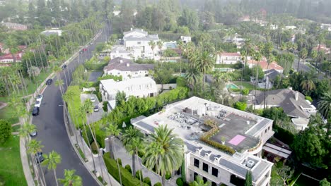Drone-Low-View-Over-Beverly-Hills-Neighborhood-Luxury-Mansion,-Villa,-Homes-with-Swimming-Pools,-Tennis-Courts
