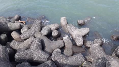 Seashore-waves-striking-black-rocks-at-Queens-necklace-marine-drive-beach-Mumbai,-India-Marine-Drive-water-waves,-panoramic-view,-Mumbai,-India