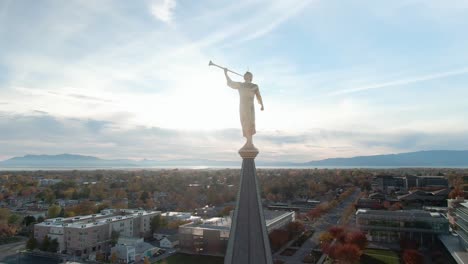 Angel-Moroni-Statue-with-Trumpet-atop-LDS-Mormon-Temple-at-Sunset-in-Provo,-Utah---Aerial-Orbit