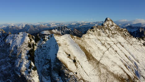 Snowy-Mountain-Peak-during-Early-Winter-at-Cape-au-Moine,-mountain-of-the-Swiss-Prealps-in-Vaud-Switzerland---aerial-pullback