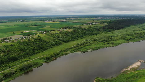 Lebendiges-Flusstal-In-Litauen-An-Bewölkten-Tagen-Mit-Kleinen-Wohngebäuden-Am-Hang-Bei-Leichtem-Regen,-Luftbild