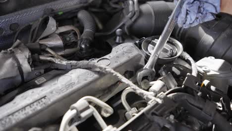 Close-up-of-unscrewing-bolts-to-check-car-engine-injectors