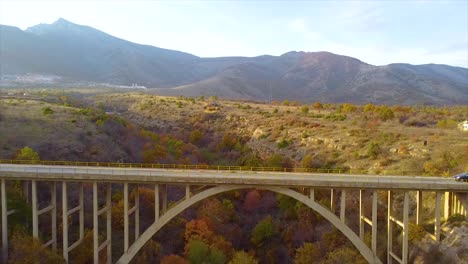 Car-driving-on-a-bridge-above-a-canyon-drone-shot