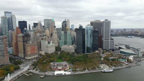 Aerial-view-overlooking-the-Battery-park-in-vibrant-fall-colors,-in-cloudy-Manhattan---tracking,-drone-shot