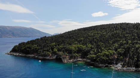 Touristen,-Die-Im-Smaragdgrünen-Kristallwasser-Des-Foki-strandes-Auf-Der-Insel-Kefalonia,-Griechenland,-Mit-Dicht-Bewaldeten-Hügeln-Schwimmen