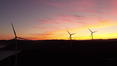 Windturbinenpark-Silhouette-Während-Des-Farbenfrohen-Himmels-Bei-Sonnenuntergang