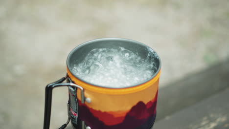Boiling-water-in-an-enamel-red-and-yellow-tourist-mug