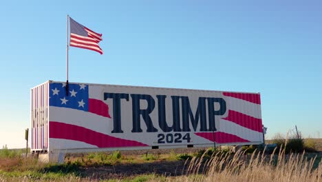 Donald-Trump-2024-Präsidentschaftswahlkampfschild-Mit-Amerikanischer-Flagge,-Die-Im-Wind-Weht