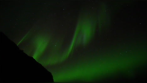 Panning-shot-of-green-Polar-lights-on-dark-sky-with-lighting-stars-in-background---Exploration-of-Aurora-Borealis-on-Iceland