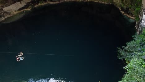 Dos-Personas-Nadando-En-Un-Cenote-De-Cueva-Subterránea