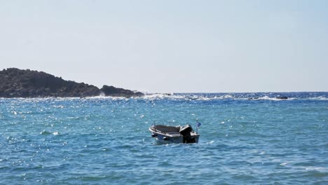Motorboat-floating-on-clear-blue-sea-in-Jerusalem-beach-in-Greece---static-shot