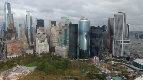Aerial-view-of-high-rise-and-foliage-covered-battery-park,-in-Manhattan,-NYC---tracking,-drone-shot