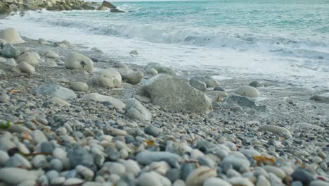 4K-Slow-motion-cinematic-shot-of-waves-hitting-rocks-on-a-beach,-at-Church-Ope,-Portland-Dorset,-in-England,-on-a-sunny-day