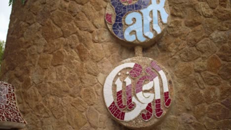 Tourist-Taking-Photo-Of-Park-Guell-Logo-Using-A-Smartphone-In-Barcelona,-Spain---handheld-shot
