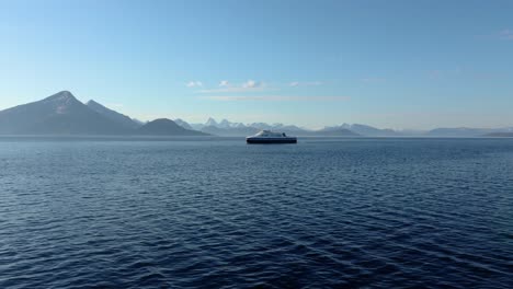 A-big-boat-goes-in-front-of-high-mountains-and-blue-sky-with-low-waves