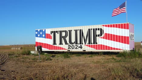 Riesiges-Donald-Trump-2024-Präsidentschaftswahlkampfschild-Mit-Amerikanischer-Flagge,-Die-Im-Wind-Weht