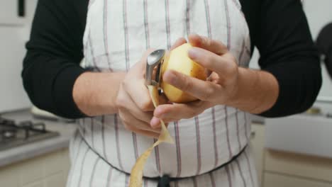 Close-up-on-chef-hands-peeling-off-potato-skin