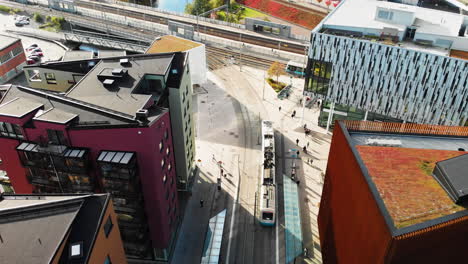Aerial-top-down-view-trams-crossing-rail-tracks-at-Gamlestaden-tram-stop,-Gothenburg