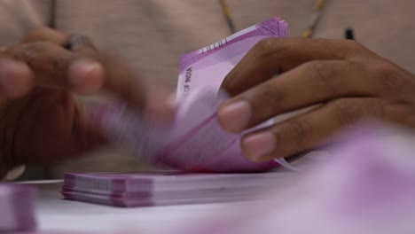 hands-counting-money-Indian-currency-notes-bundle-close-up