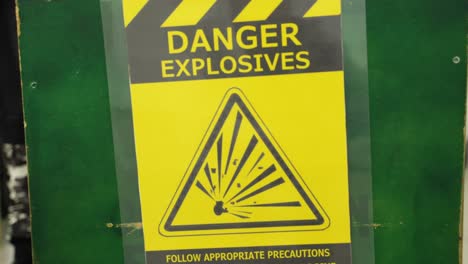 Danger-explosives-sign-board-with-people-wearing-military-outfit-in-background