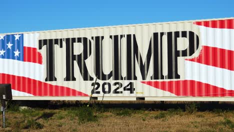 Vote-For-Donald-Trump-2024-For-President,-Election-Campaign-Yard-Sign-Painted-on-a-Large-Truck-or-Trailer-in-Rural-Farm-Land-in-the-South-or-Midwest