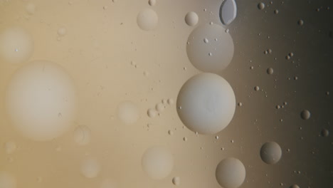 Kleine-Transparente-Luftblase,-Die-Sich-In-Einer-Leicht-Goldenen-Flüssigkeit-Bewegt
