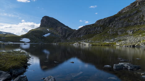 Reflections-Of-Blue-Sky-And-White-Clouds-On-The-Lake-Water-In-Storehorn,-A-Mountain-In-Hemsedal,-Norway---timelapse