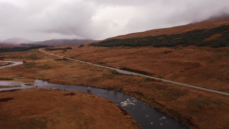 Antenne---Fluss-Orchy-Neben-Straße,-Glencoe,-Schottisches-Hochland,-Schottland,-Vorwärts