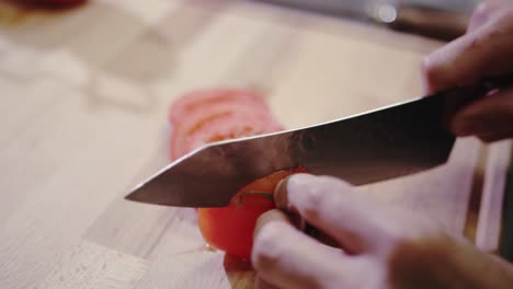 Küchenchef-Schneidet-Eine-Tomate.-Mit-Messer-Auf-Schneidebrett