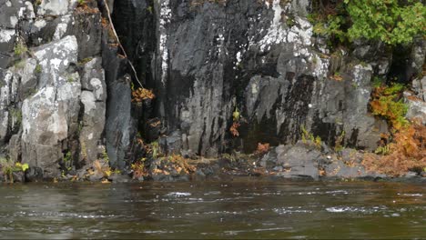 Felsige-Steinmauern-Halten-Das-Flusswasser,-Das-Mit-Hoher-Strömung-Fließt