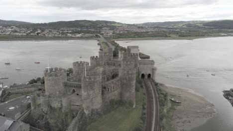 Medieval-landmark-historic-Conwy-castle-aerial-view-descending-to-Welsh-seaside-landscape-scenery