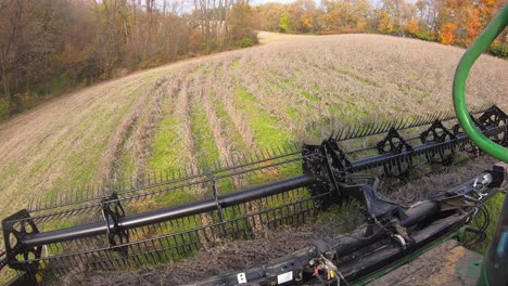 POV-of-farmer-using-a-combine-and-a-belted-soybean-header-to-harvest-beans-in-field-in-the-Medwest