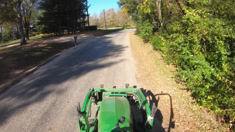 High-angle-point-of-view-while-driving-a-small-green-tractor-with-lift-forks-on-the-front