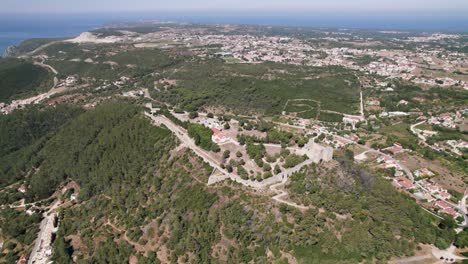 Aerial-panoramic-view-of-Sesimbra-Castle-and-surrounding-landscape,-Portugal