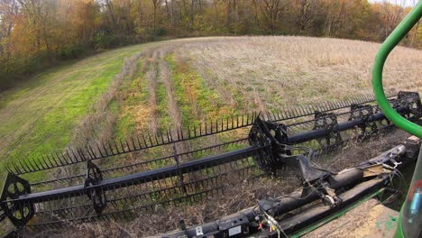 POV-of-farmer-using-a-combine-and-soybean-header-to-harvest-beans-on-the-edge-of-field-in-Midwest