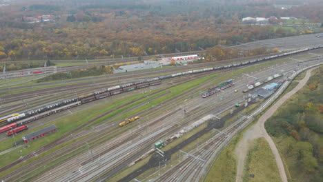 Aerial-of-long-cargo-train-slowly-leaving-a-small-town