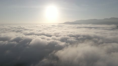El-Dron-Vuela-Hacia-Atrás-Desde-El-Sol-Con-El-Océano-De-Nubes-Debajo