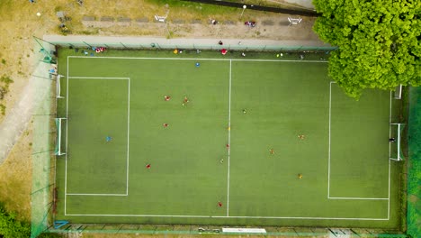 Outdoor-Football-pitch-with-People-playing-soccer---top-down-aerial-view