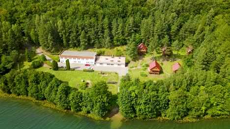 Holzhaus-Beherbergt-Unterkunft-Für-Touristen-In-Borucino,-Umgeben-Von-Dichtem-Wald,-Polen---Drohnenschuss-Umdrehen