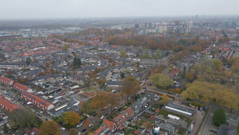 Aerial-of-a-modernized-suburban-neighborhood-with-a-large-city-in-the-background-in-autumn