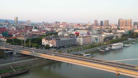 Wide-drone-shot-of-Bratislava,-Slovakia-with-the-Bridge-of-the-Slovak-National-Uprising-in-the-foreground