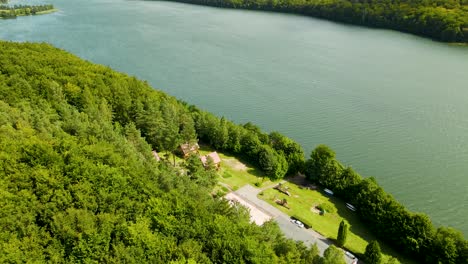 Aerial-backwards-shot-of-beautiful-natural-lake-and-beautiful-forest-trees-on-shore---Raduńskie-Dolne-Lake,Borucino