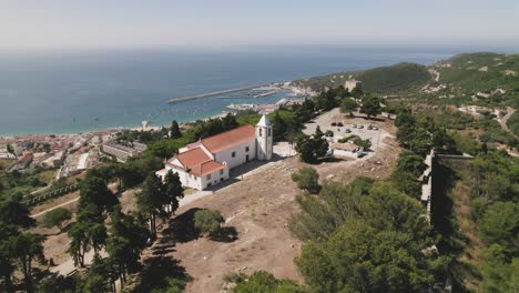 Aerial-forward-view-of-ancient-walls-with-church-and-sea-in-background