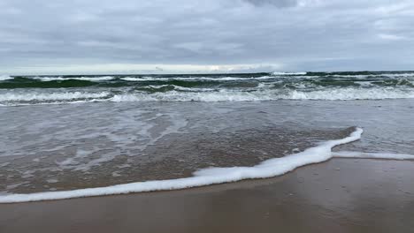 Waving-sea-by-a-sandy-beach---low-angle,-Wladyslawowo-poland
