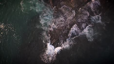 Waves-breaking-on-rocks-in-California---birds-eye-view